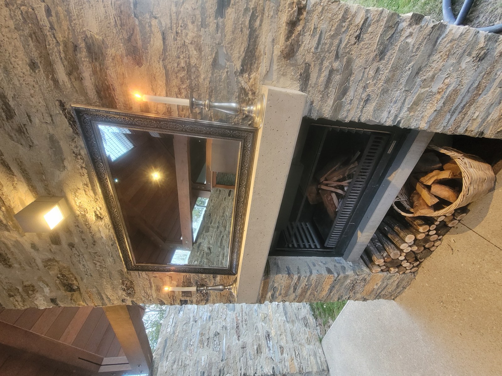 The schist fireplace, stacked with firewood