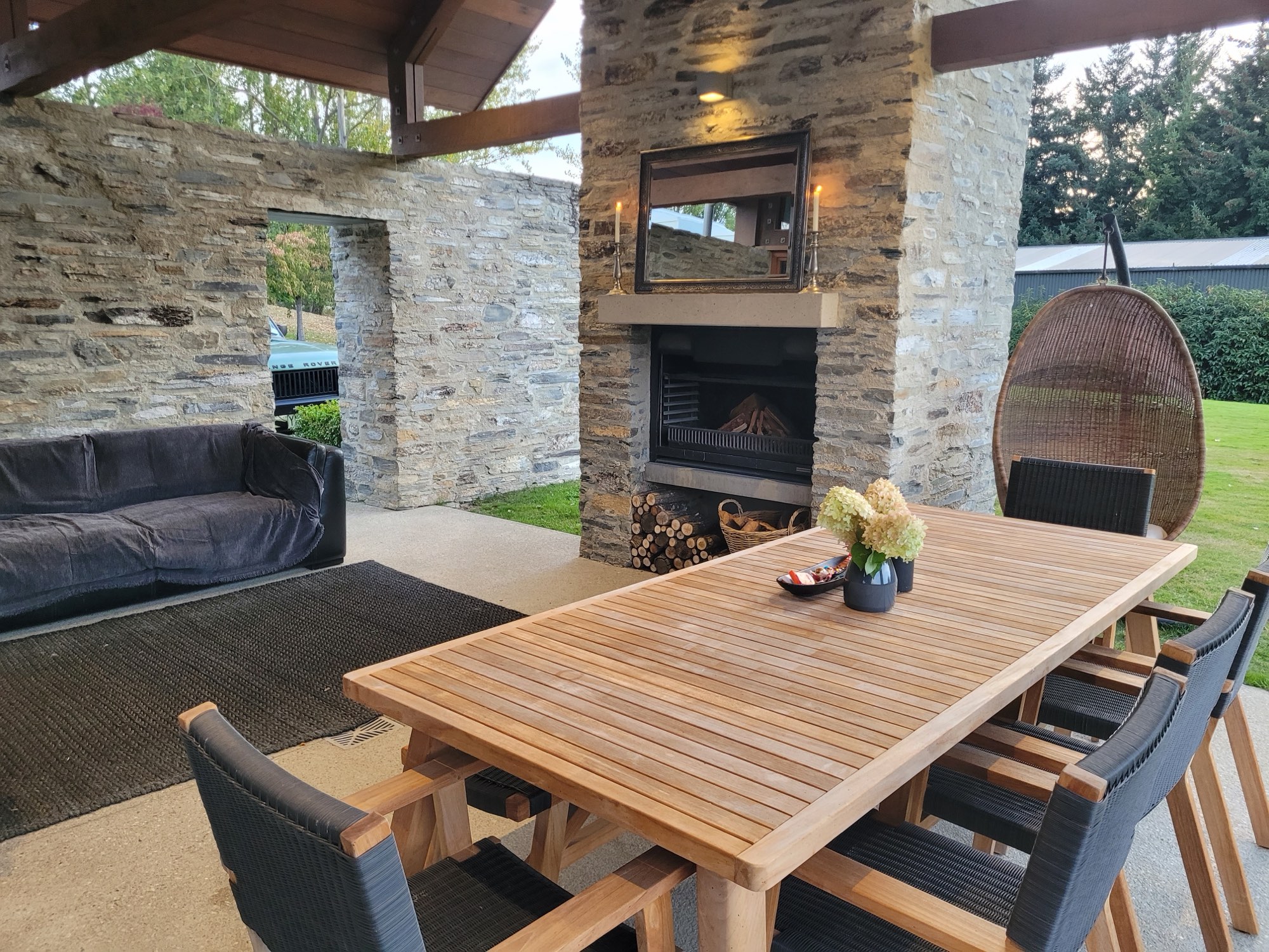 The courtyard sofa beside the schist fireplace