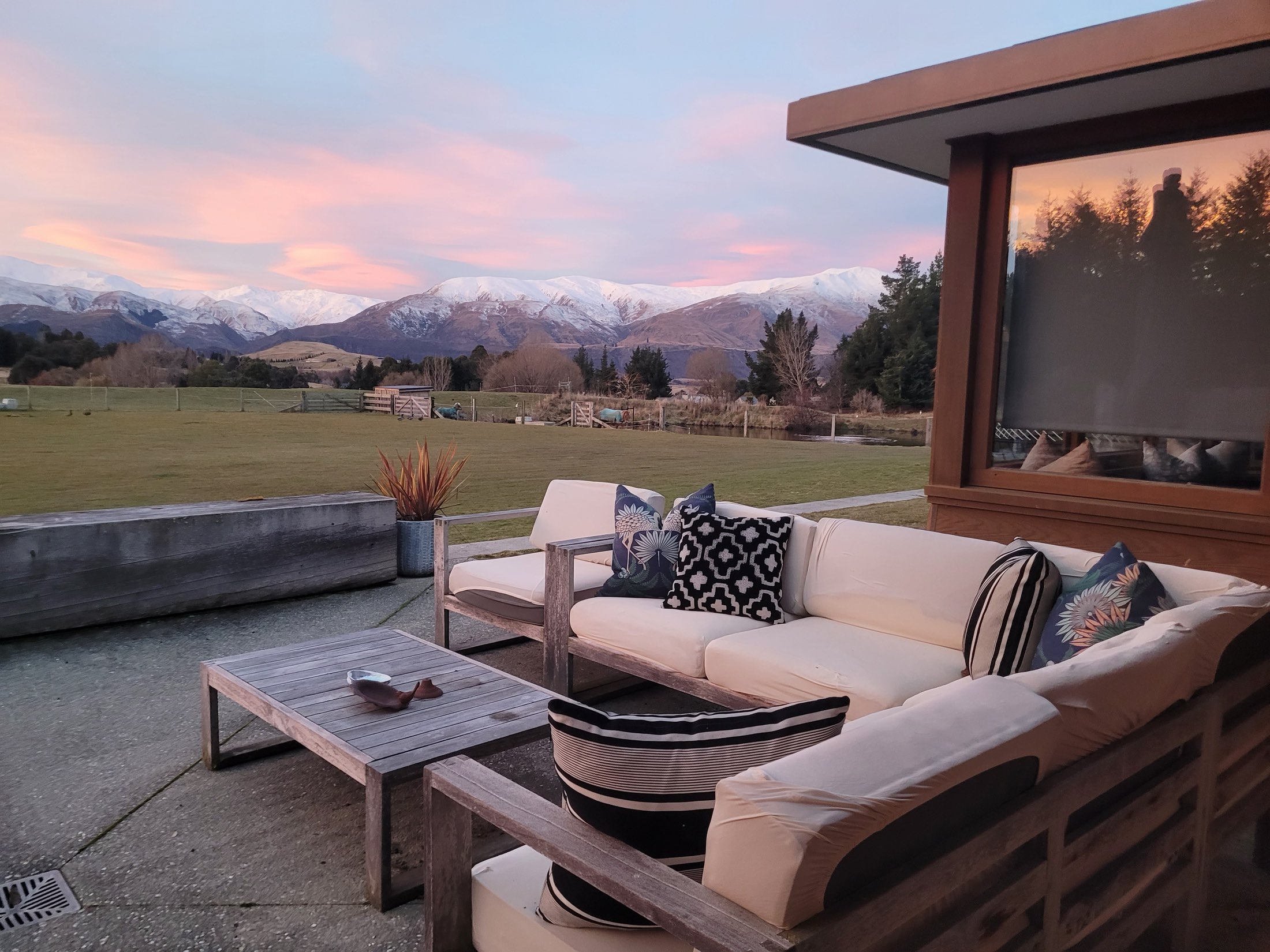 The outdoor lounge at dusk, with snow on the Remarkables behind