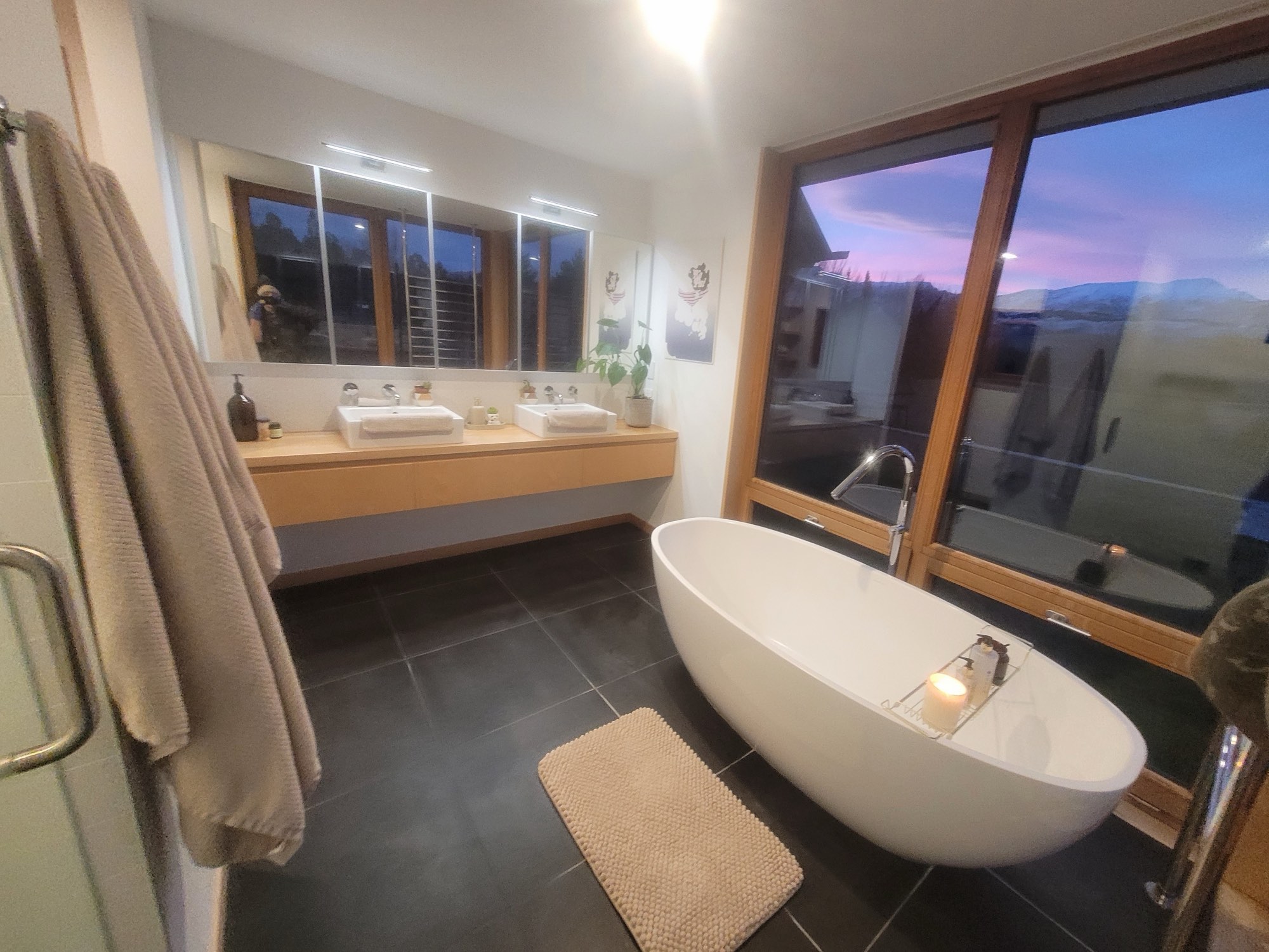 The freestanding bath, set to the view, at dusk