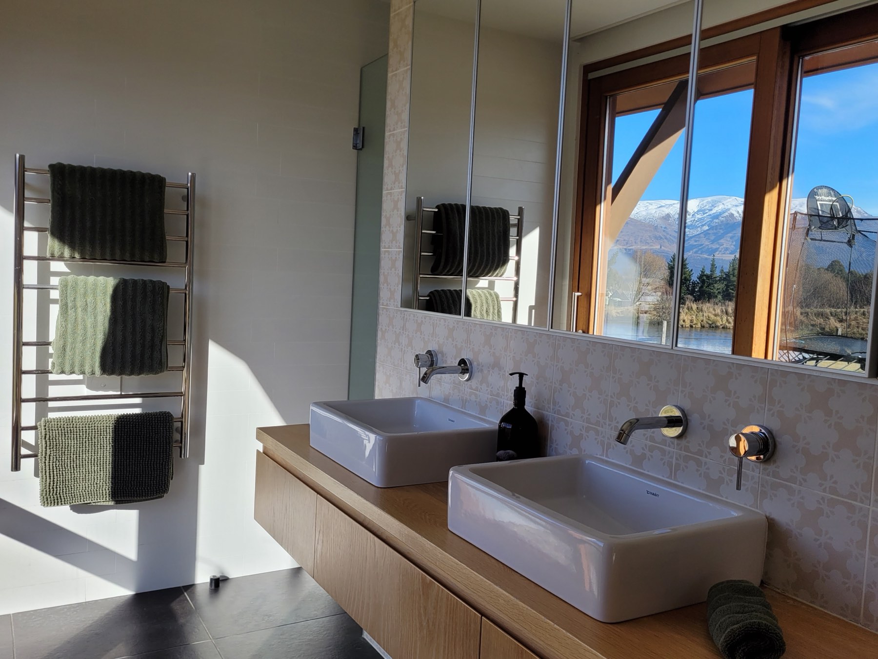 An ensuite with twin basins and a mountain outlook