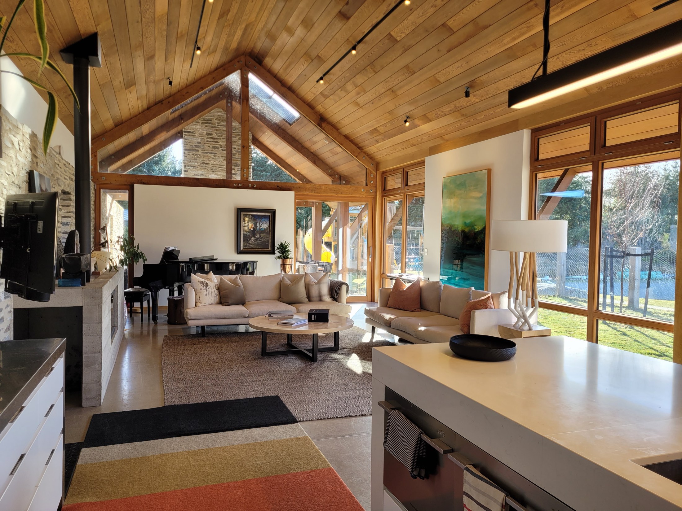 Living room with a timber cathedral ceiling and schist fireplace