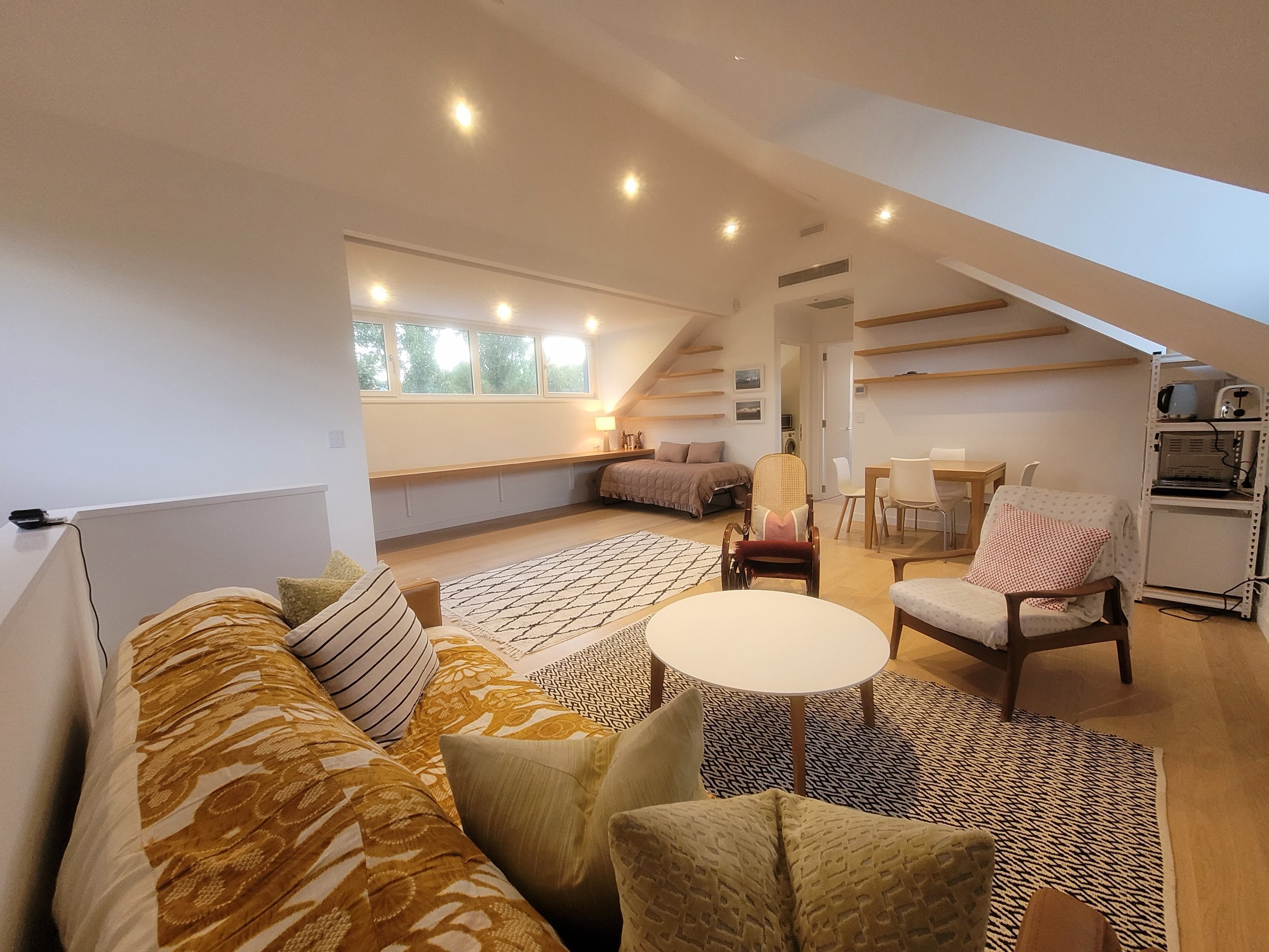 The loft's long open room, with dormer windows and the dining end beyond