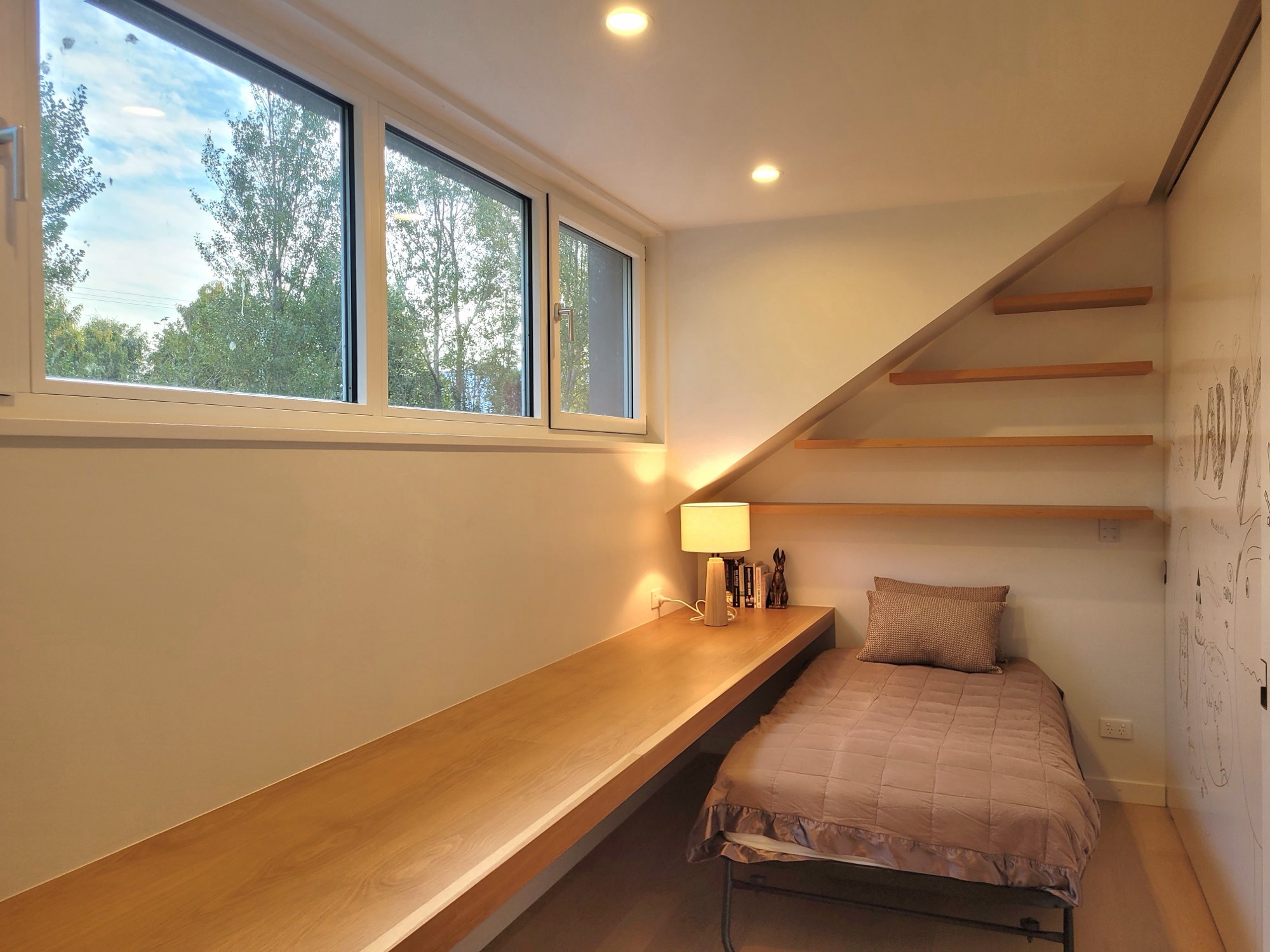 A single bed beneath the shelving
