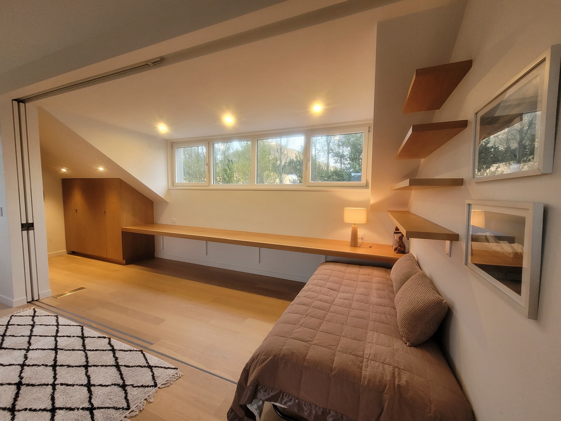 The loft’s single beds in their nook, with the long desk under the clerestory windows