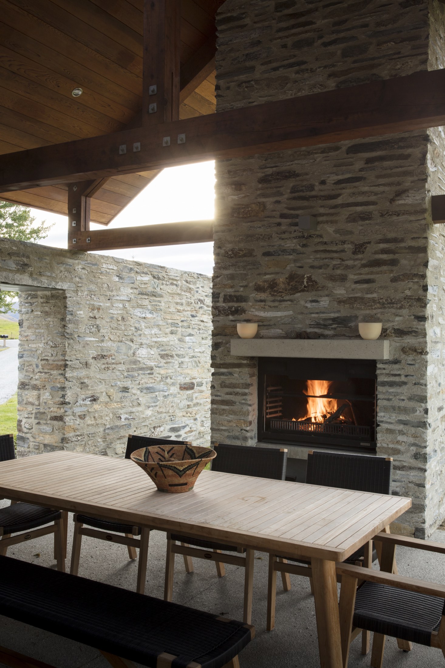 The courtyard fire, lit, with the long table beside it