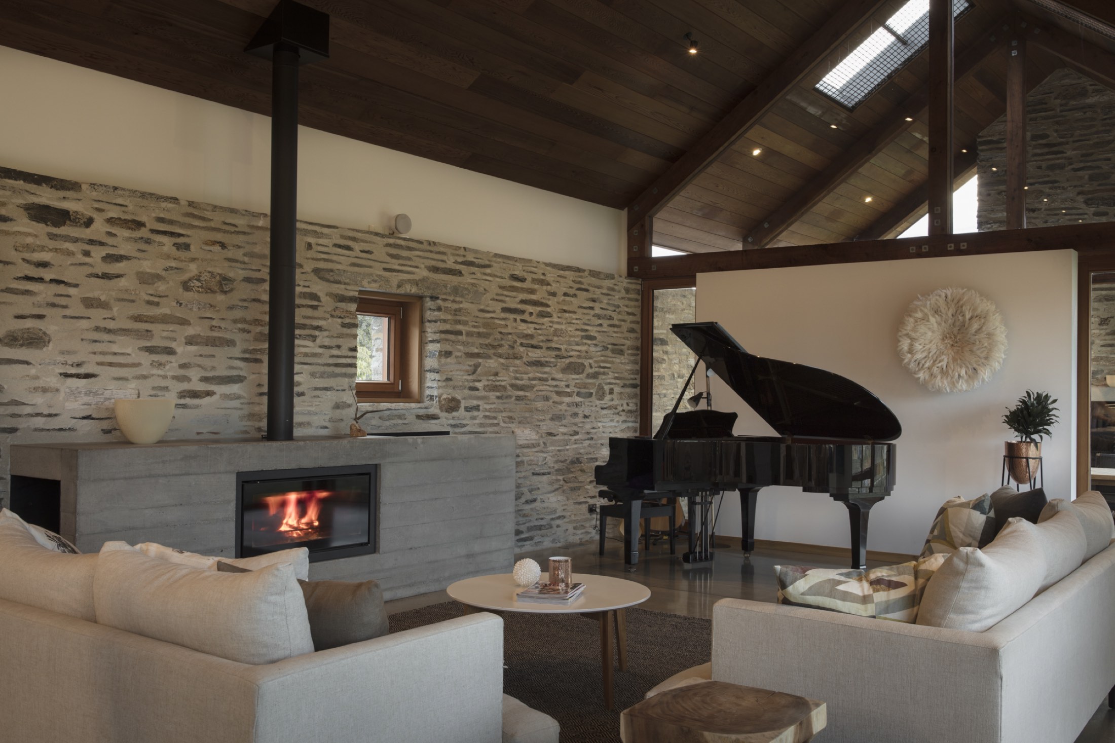 The living room: the log burner, the schist wall and the piano