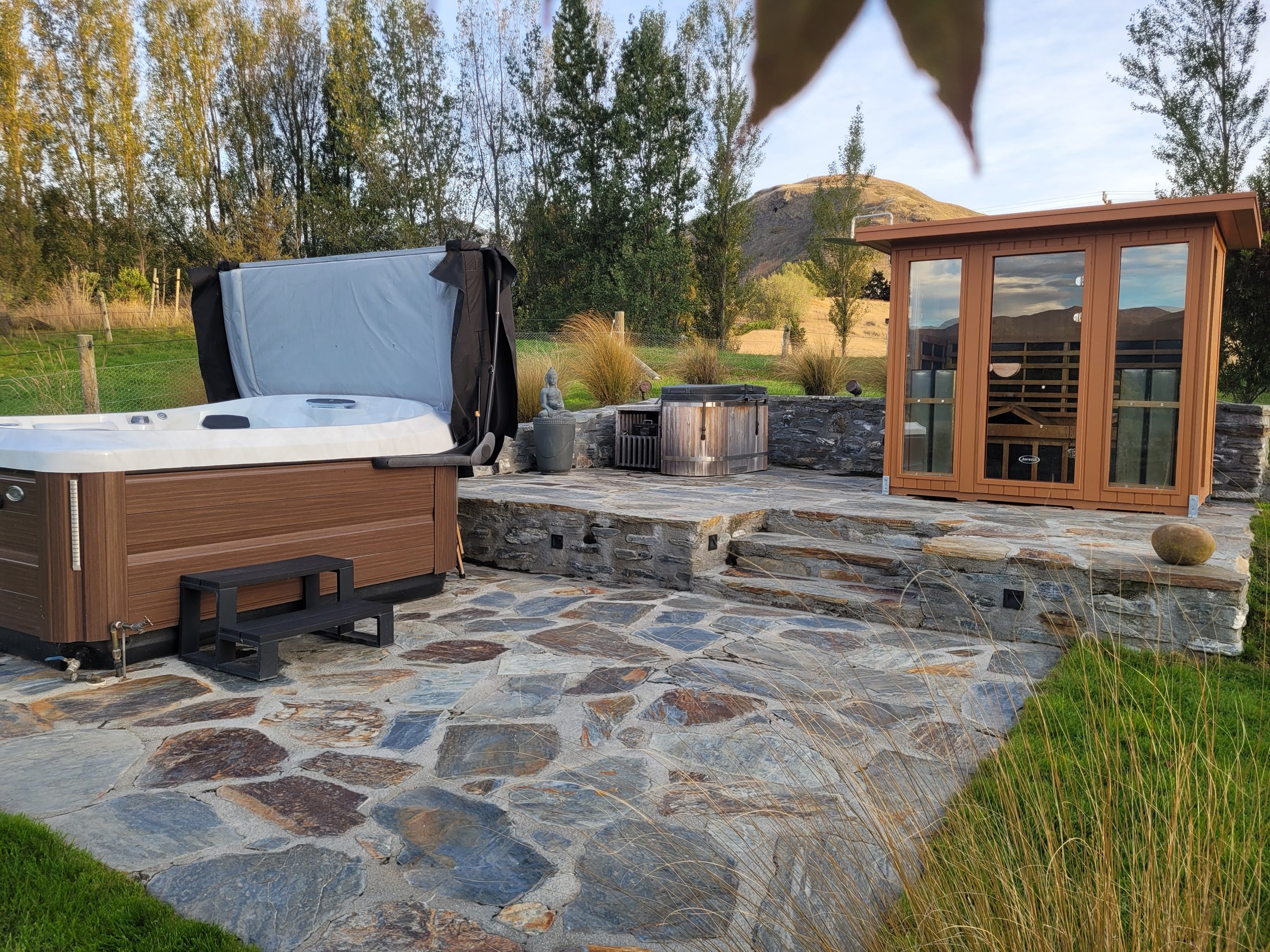 Infrared sauna cabin and outdoor spa on a schist terrace above the pond